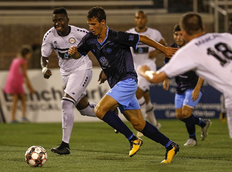 Chattanooga FC's Jonathan Ricketts (25) plays the ball amid the Atlanta Silverbacks defense during the National Premier Soccer League Southeast Conference final at Finley Stadium on Saturday, July 14, 2018, in Chattanooga, Tenn. / Staff file photo by C.B. Schmelter