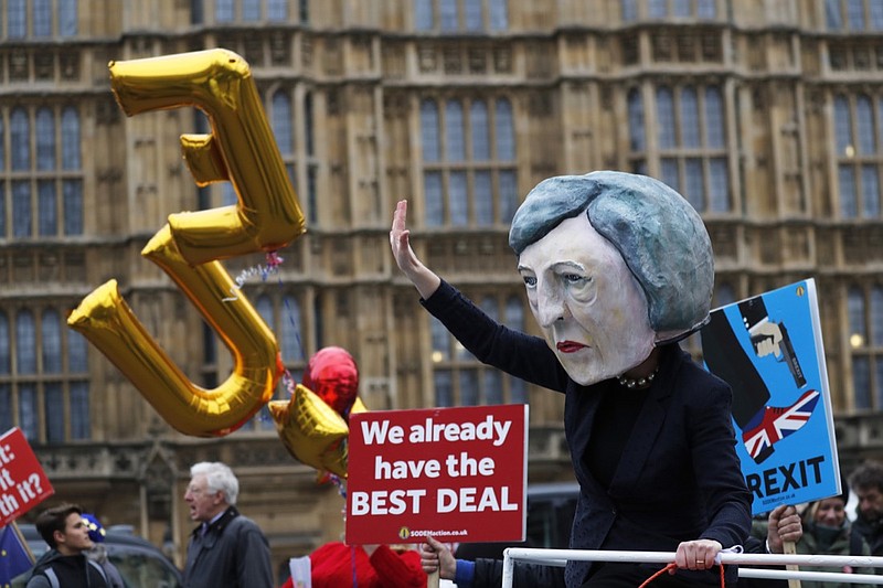 An activist from Avaaz wears a mask of Britain's Prime Minister Theresa May as Pro-European demonstrators protest opposite the Houses of Parliament in London, Tuesday, Jan. 15, 2019. Britain's Prime Minister Theresa May is struggling to win support for her Brexit deal in Parliament. Lawmakers are due to vote on the agreement Tuesday, and all signs suggest they will reject it, adding uncertainty to Brexit less than three months before Britain is due to leave the EU on March 29. (AP Photo/Frank Augstein)