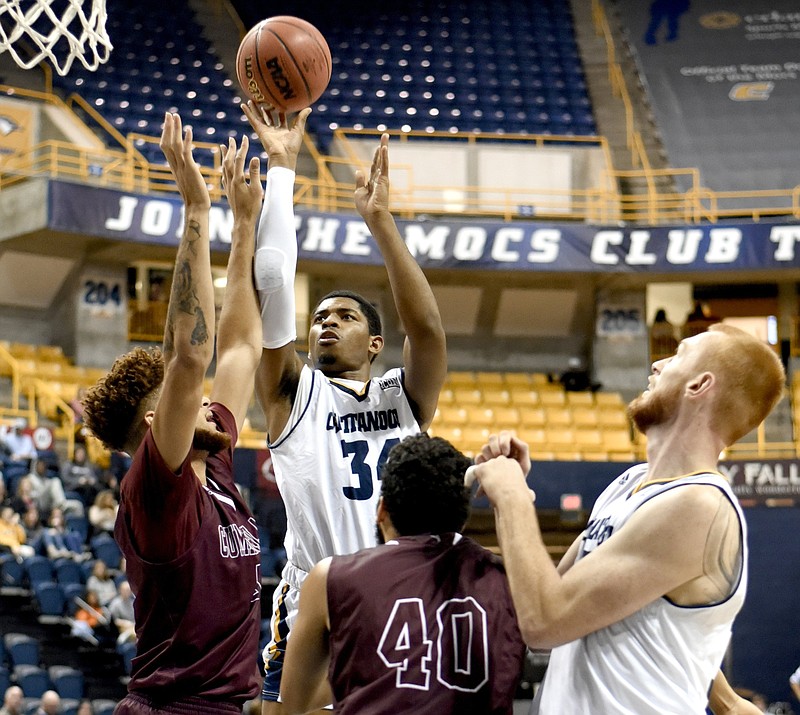 UTC's Kevin Easley shoots as teammate Thomas Smallwood, right, battles Cumberland's Isaac Stephens (40) in the paint during a game at McKenzie Arena on Nov. 13, 2018.  