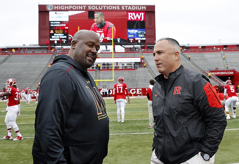 Kyle Flood, right, and Mike Locksley talk before a football game in November 2015 in Piscataway, N.J. At the time, Flood was the head coach at Rutgers and Locksley the interim coach at Maryland. Locksley left Nick Saban's Alabama staff after this past season to become the head coach at Maryland, and Flood has reportedly been hired by Saban to coach offensive linemen.