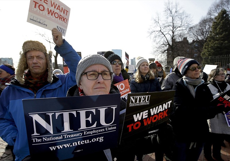 United States Department of Agriculture employee Lori Lodato, of Wilmington, Mass., display placards during a rally by federal employees and supporters, Thursday, Jan. 17, 2019, in front of the Statehouse in Boston, held to call for an end of the partial shutdown of the federal government. (AP Photo/Steven Senne)

