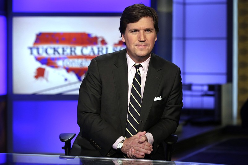 In this March 2, 2017, file photo, Tucker Carlson, host of "Tucker Carlson Tonight," poses for photos in a Fox News Channel studio in New York. (AP Photo/Richard Drew)