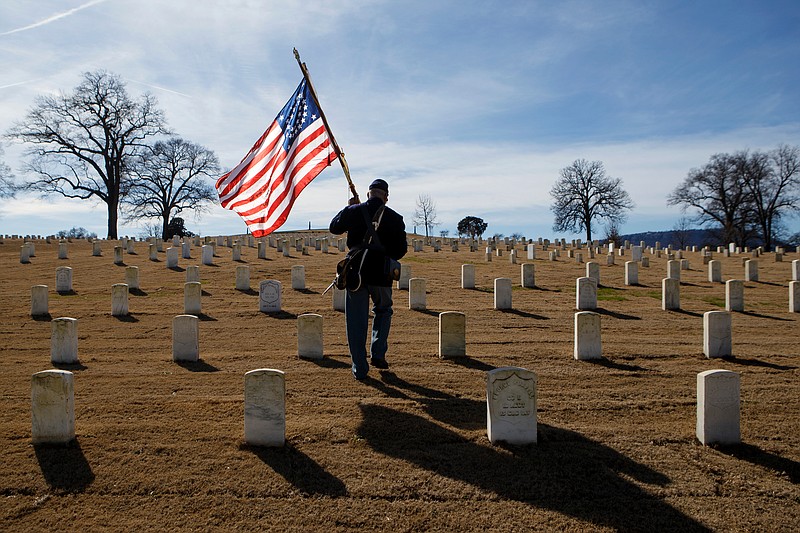 Donald Tatum, a quarter master sergeant in the 44th United States Colored Troops reenactment group, carries a Civil War-era American flag through the Chattanooga National Cemetery before a wreath laying ceremony as part of the Martin Luther King Jr. Day of Service on Monday, Jan. 21, 2019 in Chattanooga, Tenn. Hosted by Unity Group of Chattanooga, along with National Park Partners, the 44th United States Colored Troops reeenactors and the Mary Walker Historical and Educational Foundation, the wreath was laid to honor the members of the United States Colored Troops who fought in the Civil War and helped erect the Chattanooga National Cemetery. 