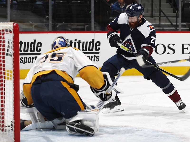 Colorado Avalanche defenseman Ian Cole, right, pursues the puck after a save by Nashville Predators goaltender Pekka Rinne in the first period of an NHL hockey game Monday, Jan. 21, 2019, in Denver. (AP Photo/David Zalubowski)

