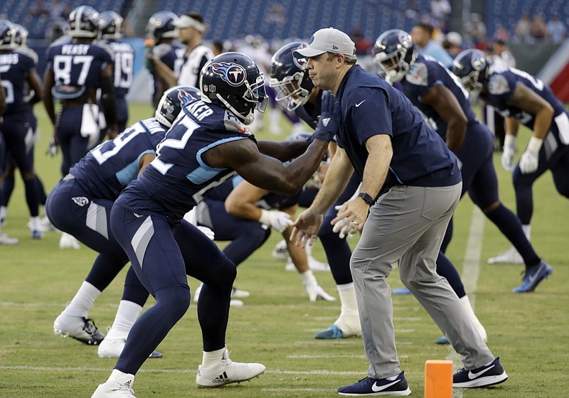File-This Aug. 30, 2018, file photo shows Tennessee Titans tight ends coach Arthur Smith, right, helping tight end Delanie Walker (82) warm up before a preseason NFL football game in Nashville, Tenn. Mike Vrabel has stayed inside the Tennessee Titans' organization for his new offensive coordinator, promoting tight ends assistant Smith to the job vacated when Matt LaFleur left for the Green Bay Packers' head coaching job. Vrabel announced the promotion Monday, jan. 21, 2019, saying he's excited for both Smith and the Titans to promote a "deserving coach."(AP Photo/James Kenney, File)

