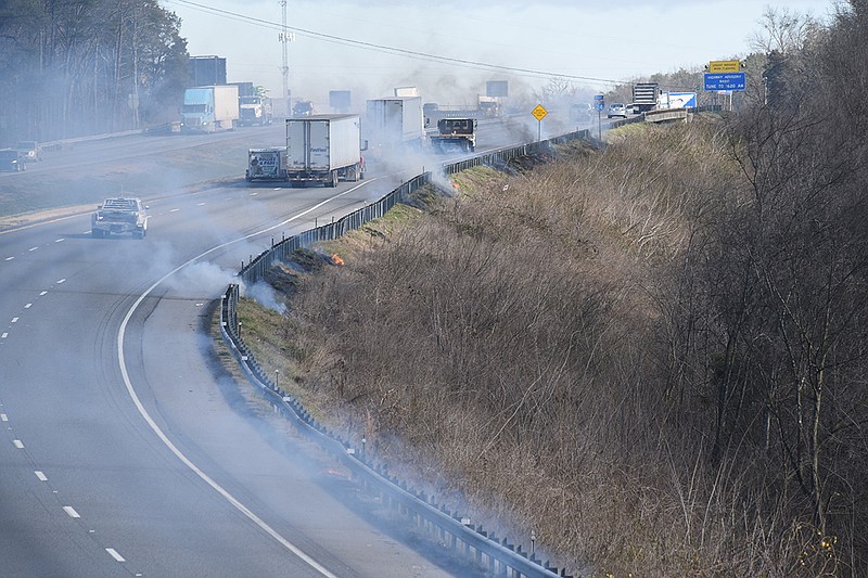 Eastbound Interstate 24 traffic motors through smoke from a roadside grass fire in Wildwood, Ga., approaching the Georgia/Tennessee state line Tuesday morning. There was no immediate explanation for the fires.