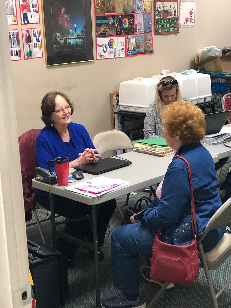 Karen Murphy, left, helps Faye Kelly, right, to help reduce Kelly's property taxes. Murphy work in the city's senior tax assistance program for senior citizens like Kelly who qualify for assistance with their property taxes. (Photo by Davis Lundy)