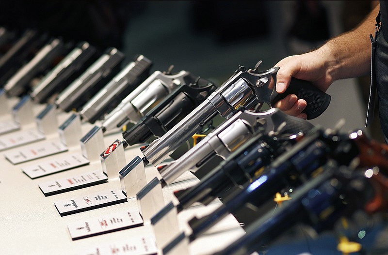 FILE - In this Jan. 19, 2016 file photo, handguns are displayed at the Smith & Wesson booth at the Shooting, Hunting and Outdoor Trade Show in Las Vegas. When gunmakers and dealers gather this week in Las Vegas for the industry's largest annual conference, they will be grappling with slumping sales and a shift in politics that many didn't envision two years ago when gun-friendly Donald Trump and a GOP-controlled Congress took office. (AP Photo/John Locher, File)