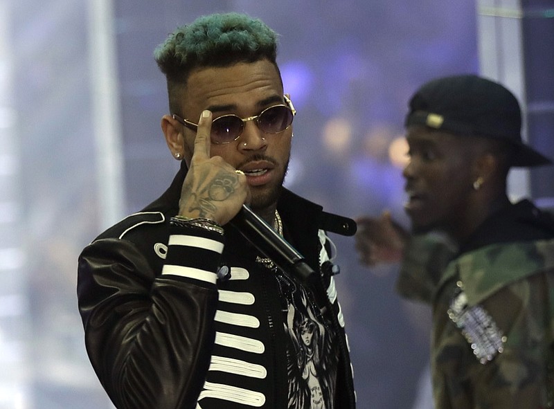 In this Sept.21, 2018, file photo, singer Chris Brown performs during Philipp Plein's women's 2019 Spring-Summer collection, unveiled during the Fashion Week in Milan, Italy. Two police officials say U.S. singer Chris Brown and two other people are in custody in Paris after a woman filed a rape complaint. (AP Photo/Luca Bruno, File)