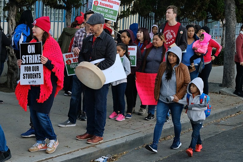 Parents arrive with their children to Evelyn Thurman Gratts Elementary School as people rally in support of Los Angeles school teachers Tuesday, Jan. 22, 2019, in Los Angeles. A strike by thousands of Los Angeles school teachers entered its second week Tuesday following a long weekend of marathon contract bargaining, and officials on both sides of the dispute planned to issue an update on where the talks stand. (AP Photo/Richard Vogel)