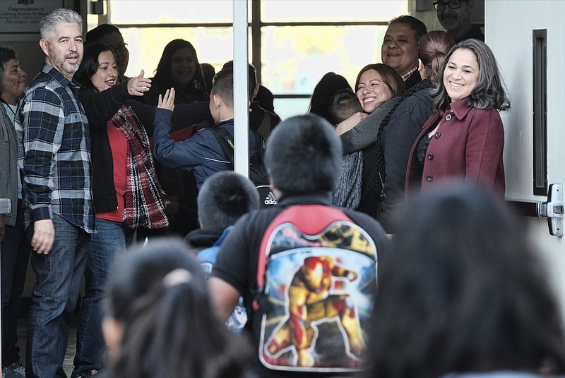 Students are welcomed with high-fives and hugs by teachers and administration upon their return to Evelyn Thurman Gratts Elementary School in downtown Los Angeles, Wednesday, Jan. 23, 2019, after a weeks longs city wide teachers strike. Thousands of Los Angeles teachers returned to work Wednesday after voting to ratify a deal between their union and school officials, ending a six-day strike in the nation's second-largest district.(AP Photo/Richard Vogel)