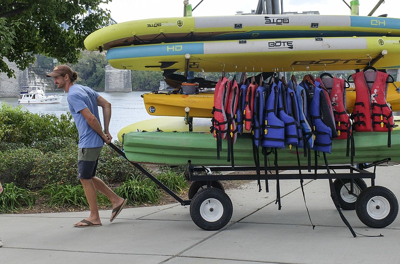 Jacob Timpa, employee for L2 Outside, pulls a cart of kayaks and paddle boards back to the shop adjacent to Coolidge Park on the Northshore. "Today, the river current is a little bit too strong, so I'm cutting it short today," Timpa said. "We are usually out here daily from 10 to 7," he said.