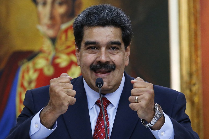 Venezuelan President Nicolas Maduro holds up his fists during a press conference at the country's presidential palace in Caracas, Venezuela, on Friday.