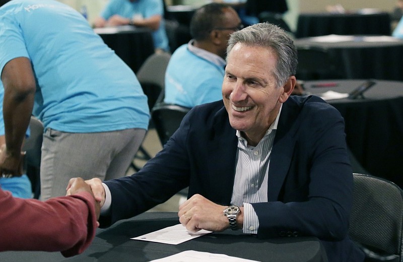 FILE - In this May 19, 2017, file photo, Starbucks CEO Howard Schultz, right, shakes hands with a job seeker during the Opportunity Fair and Forum employment event in Dallas. For someone who has given about $150,000 to Democratic campaigns over the years, Schultz is generating tepid, or even hostile, responses within the party as he weighs a presidential bid in 2020. That's because reports have suggested he's considering running as an independent, a prospect that could draw support away from the eventual Democratic nominee and hand President Donald Trump another four years in office, many fret. (AP Photo/LM Otero, File)

