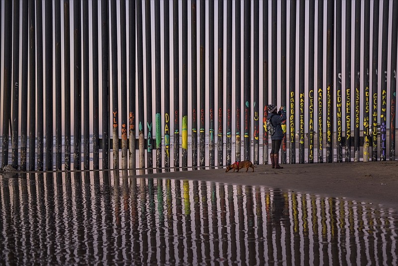 In this Jan. 3, 2019, file photo, a woman takes a photo by the border fence between San Diego, Calif., and Tijuana, as seen from Mexico. The top House Republican says a bipartisan border security compromise that Congress hopes to produce doesn't have to include the word "wall." (AP Photo/Daniel Ochoa de Olza, File)