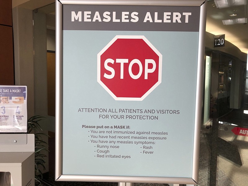 Signs posted at The Vancouver Clinic in Vancouver, Wash., warn patients and visitors of a measles outbreak on Wednesday, Jan. 30, 2019. The outbreak has sickened 39 people in the Pacific Northwest, with 13 more cases suspected. At least one patient who was sick with the measles has come to this clinic for treatment since the outbreak began Jan. 1, 2019. (AP Photo/Gillian Flaccus)

