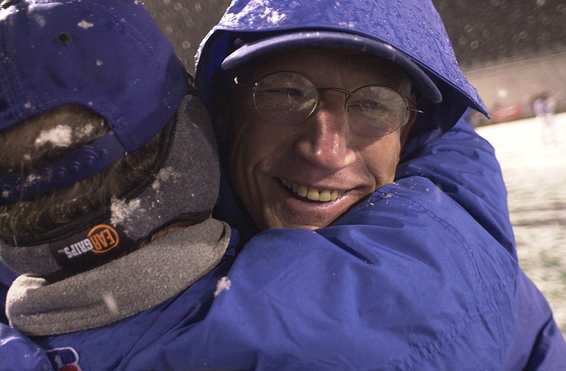 Red Bank football coach Tom Weathers smiles as he is hugged by one of his assistants after the Lions won the TSSAA Class 5A state title in 2000. The Lions beat Murfreesboro's Riverdale 27-7 in a snowstorm at Middle Tennessee State University.