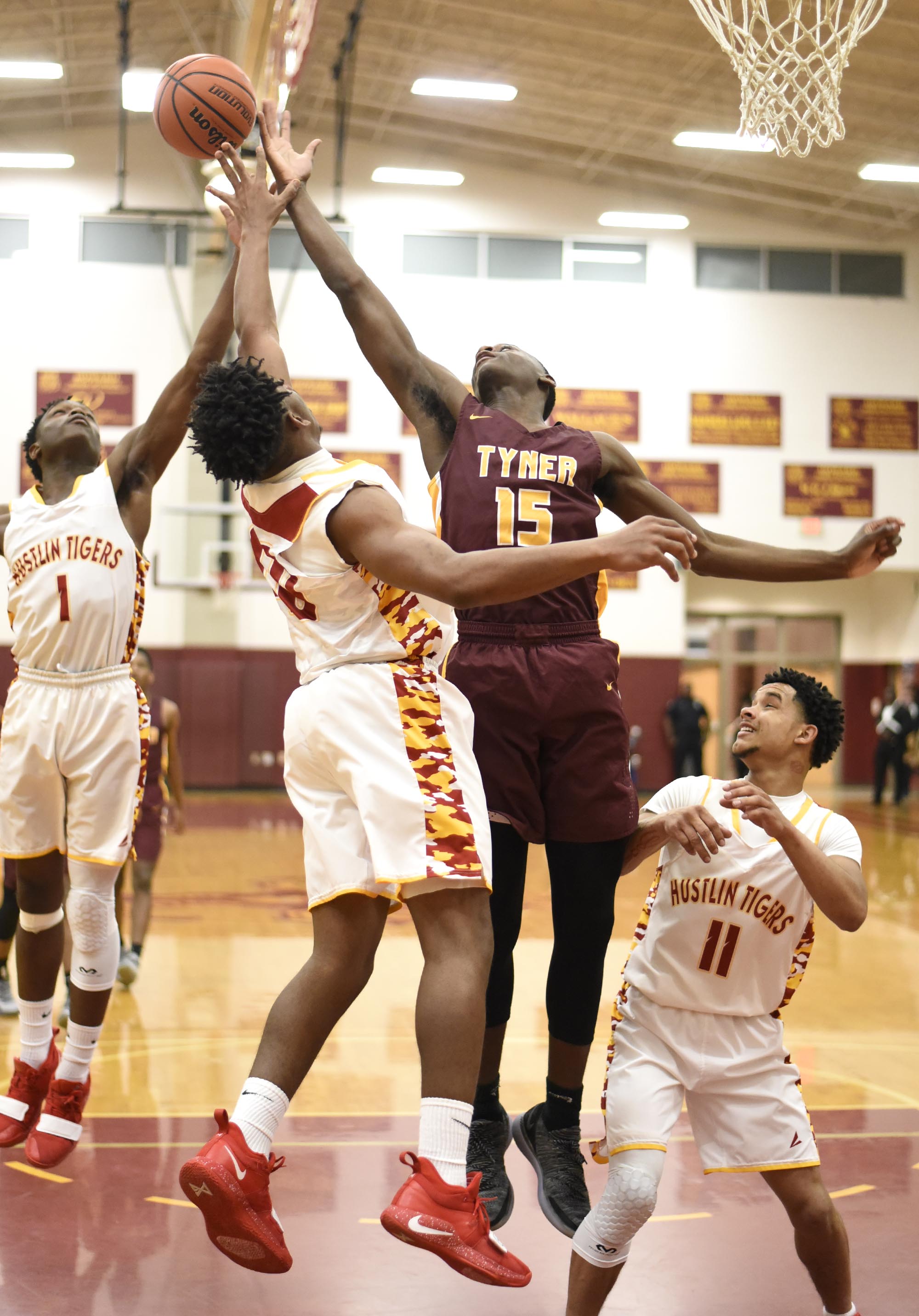 Tyner's Nieagell Sturkey (15) strains for a rebound against Howard's Demetrius Bowens (1) and Telijah Snow (40). Howard's Dewayne Lowry (11) looks on. The Tyner Rams visited the Howard Hustling Tigers in TSSAA boys' basketball on February 1, 2019.