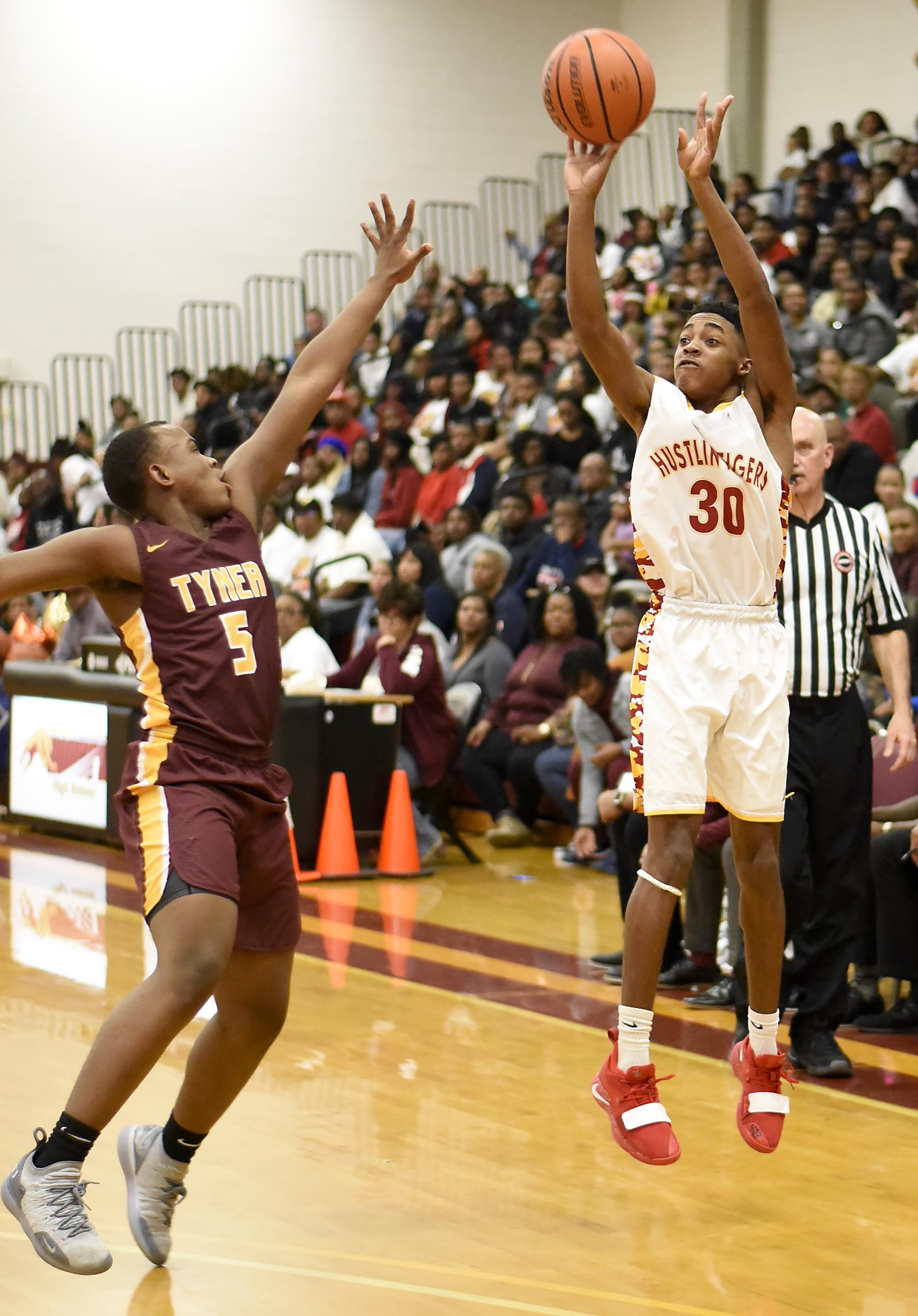 Howards's Dicorius Knight (3) shots a three-point jumper over Tyner's Jeremiah Melton (5). The Tyner Rams visited the Howard Hustling Tigers in TSSAA boys' basketball on February 1, 2019.