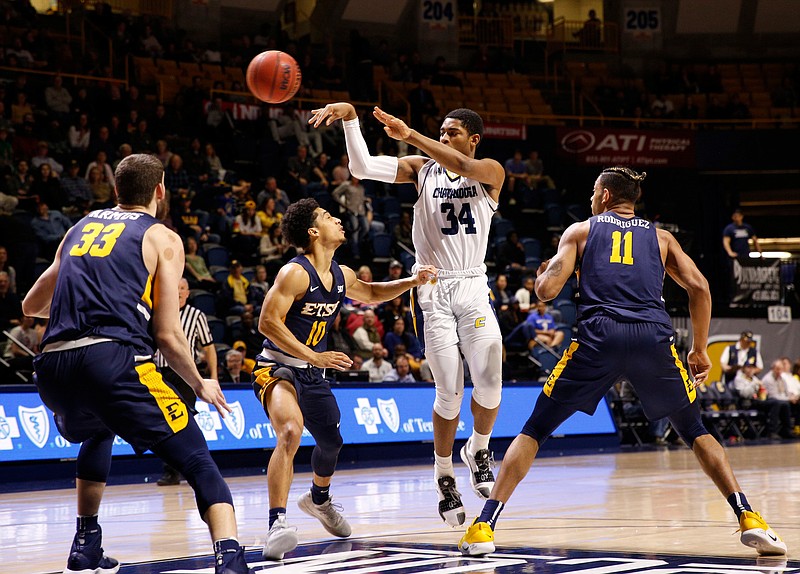 Chattanooga forward Kevin Easley (34) passes away from ETSU defenders Mladen Armus (33), Patrick Good (10), and Jeromy Rodriguez (11) during the Mocs' home basketball game against the ETSU Buccaneers at McKenzie Arena on Saturday, Feb. 2, 2019, in Chattanooga, Tenn. 