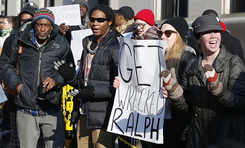 Demonstrators hold signs and chant outside the governor's office at the capitol in Richmond, Va., Saturday, calling for the resignation of Gov. Ralph Northam. (AP Photo/Steve Helber)