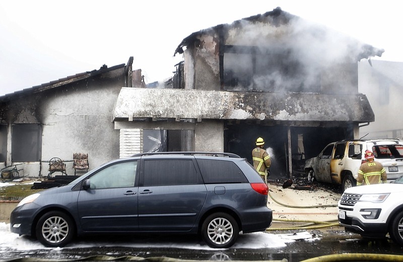 Firefighters work the scene of a deadly plane crash in the residential neighborhood of Yorba Linda, Calif., Sunday, Feb. 3, 2019. The Federal Aviation Administration said a twin-engine Cessna 414A crashed in Yorba Linda shortly after taking off from the Fullerton Municipal Airport. (AP Photo/Alex Gallardo)