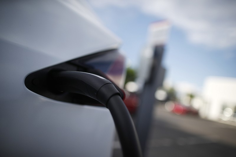 FILE- In this May 27, 2018, photo a 2018 Model X is plugged into a charging station at a Tesla dealership in Littleton, Colo. Cold temperatures can sap electric car batteries, temporarily reducing their range by more than 40 percent when interior heaters are used, a new study found. The study of five electric vehicles by AAA also found that high temperatures can cut into battery range, but not nearly as much as the cold. The range returns to normal in more comfortable temperatures. (AP Photo/David Zalubowski, File)