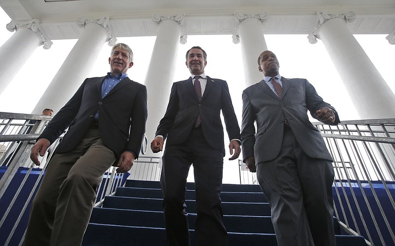 In this Jan. 12, 2018 file photo, Virginia Gov.-elect, Lt. Gov Ralph Northam, center, walks down the reviewing stand with Lt. Gov-elect, Justin Fairfax, right, and Attorney General Mark Herring at the Capitol in Richmond, Va. The political crisis in Virginia exploded Wednesday, Feb. 6, 2019, when the state's attorney general confessed to putting on blackface in the 1980s and a woman went public with detailed allegations of sexual assault against the lieutenant governor. With Northam's career already hanging by a thread over a racist photo, the day's developments threatened to take down all three of Virginia's top elected officials. (AP Photo/Steve Helber, File)