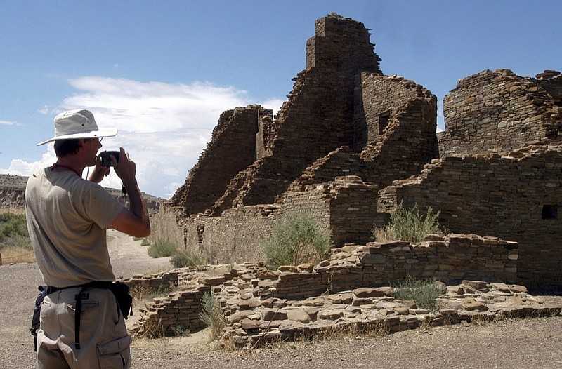 FILE - In this Aug. 10, 2005, file photo, tourist Chris Farthing from Suffolks County, England, takes a picture while visiting Chaco Culture National Historical Park in northwestern New Mexico. U.S. land managers no longer plan to move forward in March with the sale of oil and gas leases that include land near Chaco Culture National Historical Park. The decision Friday, Feb. 8, 2019, by the federal Bureau of Land Management comes after tribal leaders and others criticized the agency for pushing ahead with drilling permit reviews and preparations for energy leases near the site. (AP Photo/Jeff Geissler, File)

