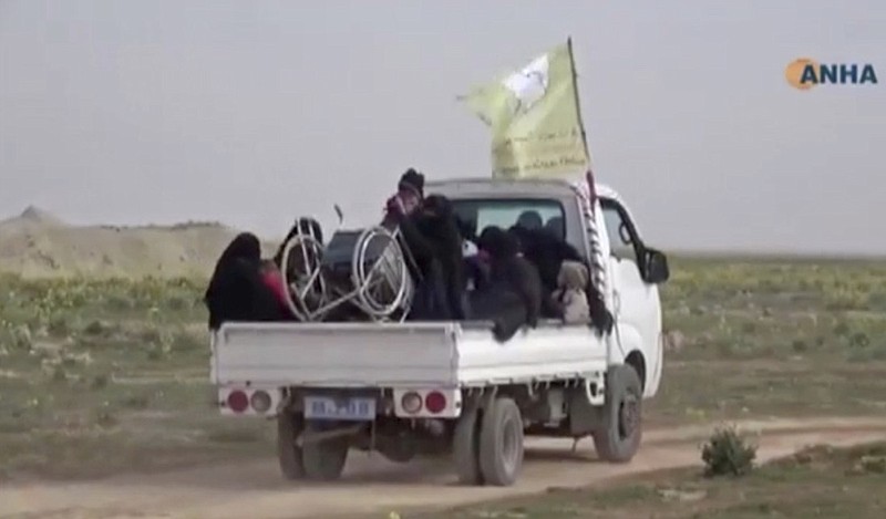 In this Sunday, Feb. 10, 2019, image from video provided by Hawar News Agency, ANHA, an online Kurdish news service, civilians flee fighting near Baghouz, Syria. Fierce fighting was underway Monday between U.S.-backed Syrian forces and the Islamic State group around the extremists' last foothold in eastern Syria. The capture of the IS-held village of Baghouz and nearby areas would mark the end of a four-year global war to end IS' territorial hold over large parts of Syria and Iraq, where the group established its self-proclaimed "caliphate" in 2014. (ANHA via AP)