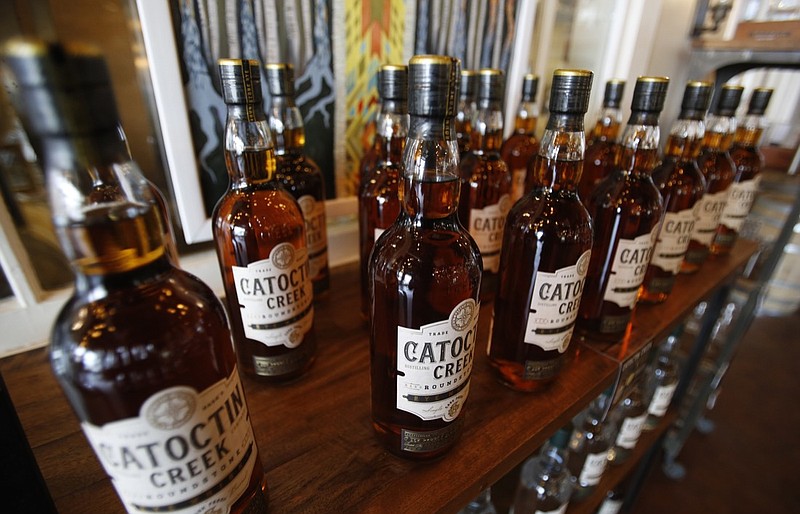 In this June 20, 2018, file photo, Catoctin Creek Distillery whiskey is on display in a tasting room in Purcellville, Va. Retaliatory tariffs caused a sharp downturn in American whiskey exports in the last half of 2018 as distillers started feeling the pain from getting caught up in global trade disputes, an industry trade group said Tuesday, Feb. 12, 2019. Catoctin Creek Distillery has a couple hundred cases of its rye whiskey sitting in a European warehouse. The inventory was built up in anticipation of growing European sales in 2018. But since the tariffs took effect, their sales in Italy and Germany have plunged, and its plans of expanding to the United Kingdom are on hold, said its co-founder and general manager, Scott Harris. (AP Photo/Steve Helber, File)
