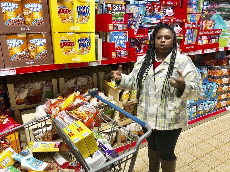 In this Sunday, Feb. 10, 2019 photo, Laquesha Russell, a 36-year-old home health care worker who makes $10.78 an hour, speaks during an interview as she shops for groceries for her four children in Springfield, Ill. Nearly a quarter of workers in Illinois would see their pay almost double under a proposal nearing final approval in the Legislature, but inflation will take a huge bite by the time the state's minimum wage reaches $15 an hour in 2025. Business owners complain that the phase-in is too fast. But Russell said, "it's going to be a long process to get up to $15." (AP Photo/John O'Connor)

