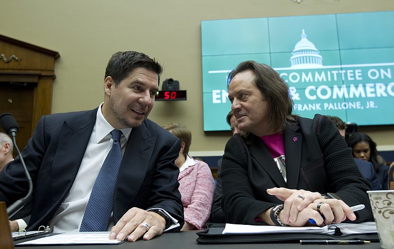 Sprint Corporation Executive Chairman Marcelo Claure, left, speaks with T-Mobile US CEO and President John Legere during the House Commerce subcommittee hearing on Capitol Hill in Washington, Wednesday, Feb. 13, 2019. (AP Photo/Jose Luis Magana)