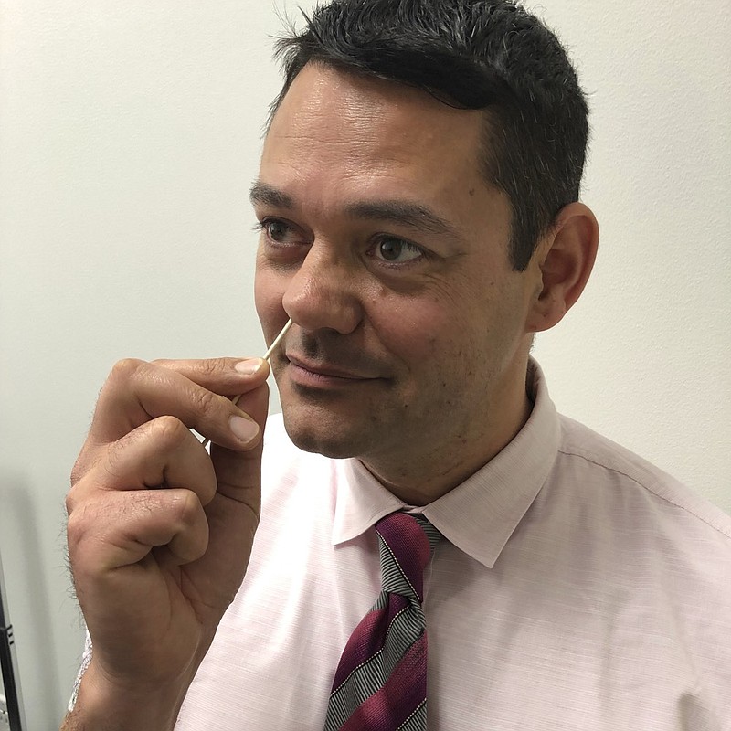 In this Monday, Feb. 11, 2019 photo provided by Dr. Susan Huang of the University of California, Irvine School of Medicine, researcher Raheeb Saavedra demonstrates how to use a medicated ointment for a study on preventing superbug infections. Hospitalized patients who harbor superbugs can cut their risk of developing full-blown infections if they swab medicated goo in their nose and use special soap and mouthwash for six months after going home, a study published on Wednesday, Feb. 13, 2019 finds. (Susan Huang via AP)

