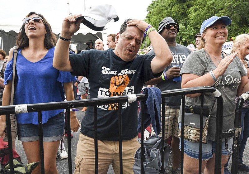 David Galvohn, center, of Sacramento, reacts to the first sounds of Emilio Castillo and Tower of Power Wednesday, June 13, 2018, at the Bud Light stage. His wife, Maria, left, and Andy Galiano, of New Orleans, party hardy on the front row at Riverbend.