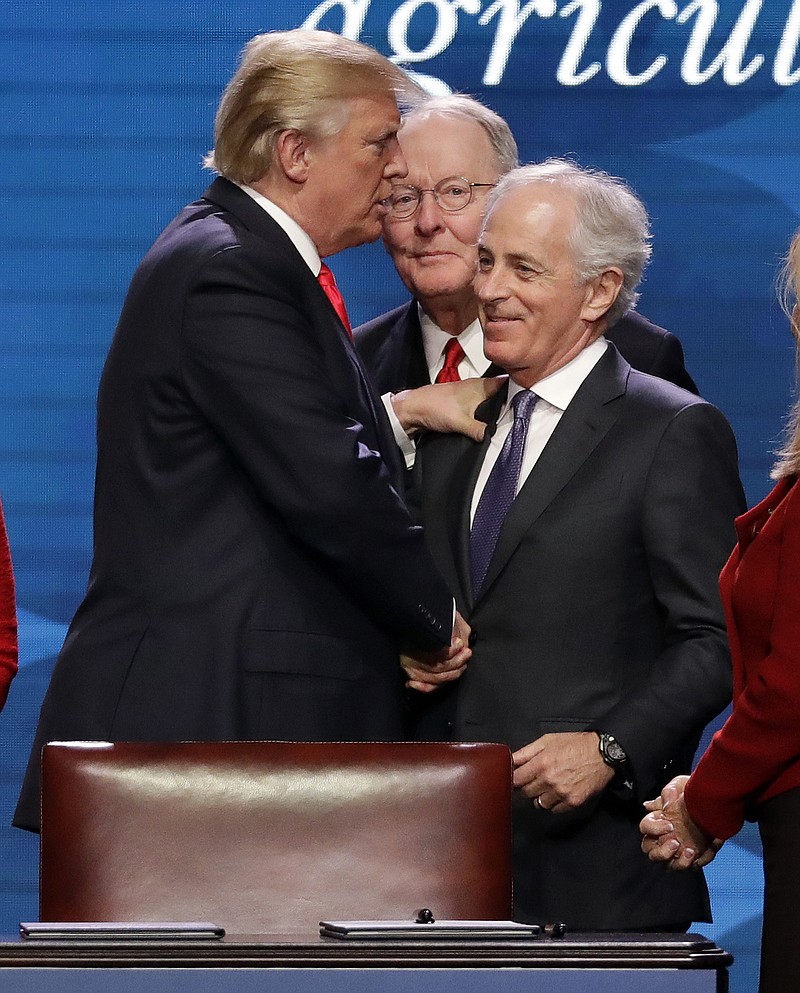 President Donald Trump mingles with Tennessee senators in January 2018 at the American Farm Bureau Federation annual convention in Nashville. He shakes hands with then-Sen. Bob Corker and behind them is Sen. Lamar Alexander. (AP Photo/Mark Humphrey)