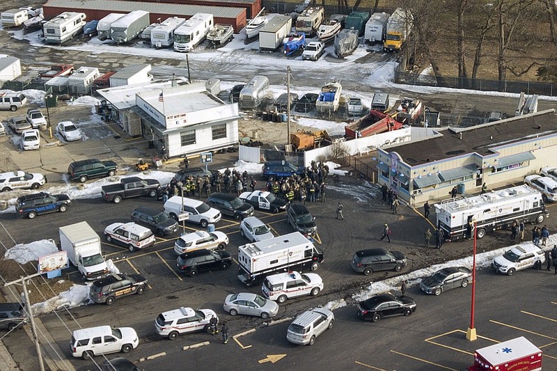 First responders and emergency vehicles are gathered near the scene of a shooting at an industrial park in Aurora, Ill., on Friday, Feb. 15, 2019. (Bev Horne/Daily Herald via AP)