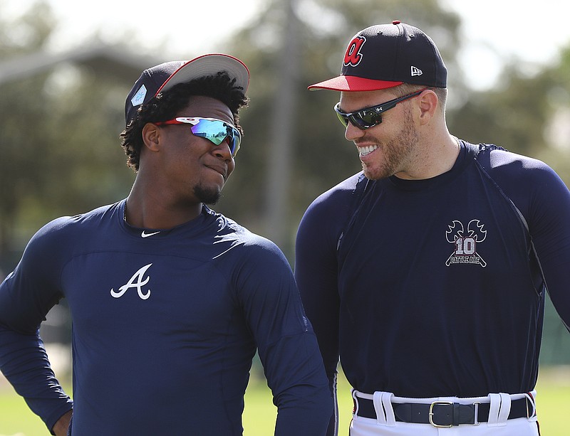 Atlanta Braves outfielder Ronald Acuna Jr., left, and first baseman Freddie Freeman share a laugh while taking the field for the team's first day of spring training on Saturday.