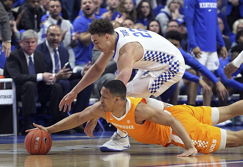 Kentucky's Reid Travis, top, and Tennessee's Grant Williams chase down a loose ball during the first half of Saturday night's top-five showdown in Lexington, Ky.
