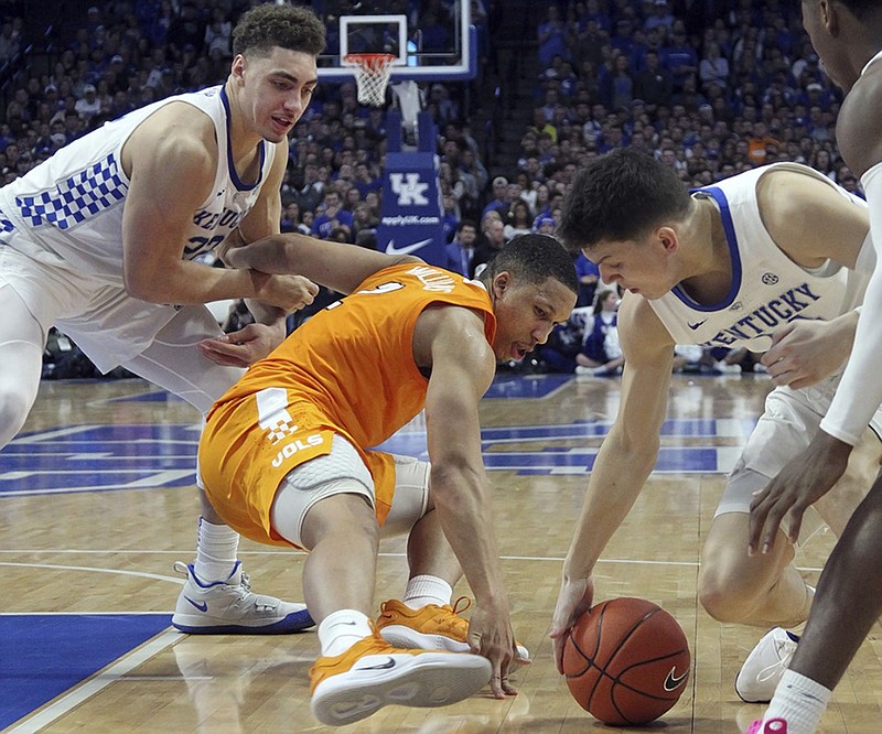 Tennessee's Grant Williams, middle, tries to pull in a loose ball between Kentucky's Reid Travis, left, and Tyler Herro during the second half of Saturday night's game in Lexington, Ky. Kentucky won 86-69.