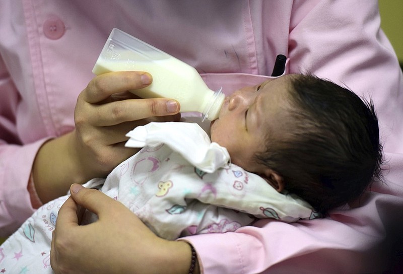 In this Jan. 19, 2019, photo, a nurse feeds a newborn baby at a hospital in Fuyang in central China's Anhui province. Facing a future demographic crisis and aging society, China's leaders are desperate to encourage higher fertility rates. But the country's bureaucrats don't seem to have gotten the message, fining a couple in a recent widely publicized case for having a third child against the strict letter of the law. That has sparked outrage among the public, who are venting their anger at officials who long persecuted couples for violating the now-scrapped "one-child policy."(Chinatopix via AP)

