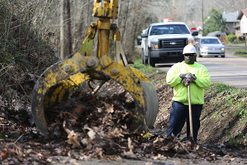 Robert Officer, a crew supervisor with Public Works, watches as leaves and other debris are picked up from drainage ditches along Ely Road Monday, February 18, 2019 in Chattanooga, Tennessee. Officer and other Public Works employees were dispatched to several areas that are know hot spots prone to issues in major rain events. 