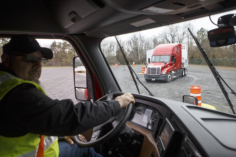 A truck is seen on the driving range through the windshield of Trainer, Mentor and Road Team Captain Don Blair's truck as he demos the serpentine course at the U.S. Xpress Tunnel Hill facility on Tuesday, Feb. 19, 2019 in Tunnel Hill, Ga. The driving range is part of the Professional Driver Development program and offers potential drivers a course to practice different maneuvers. 