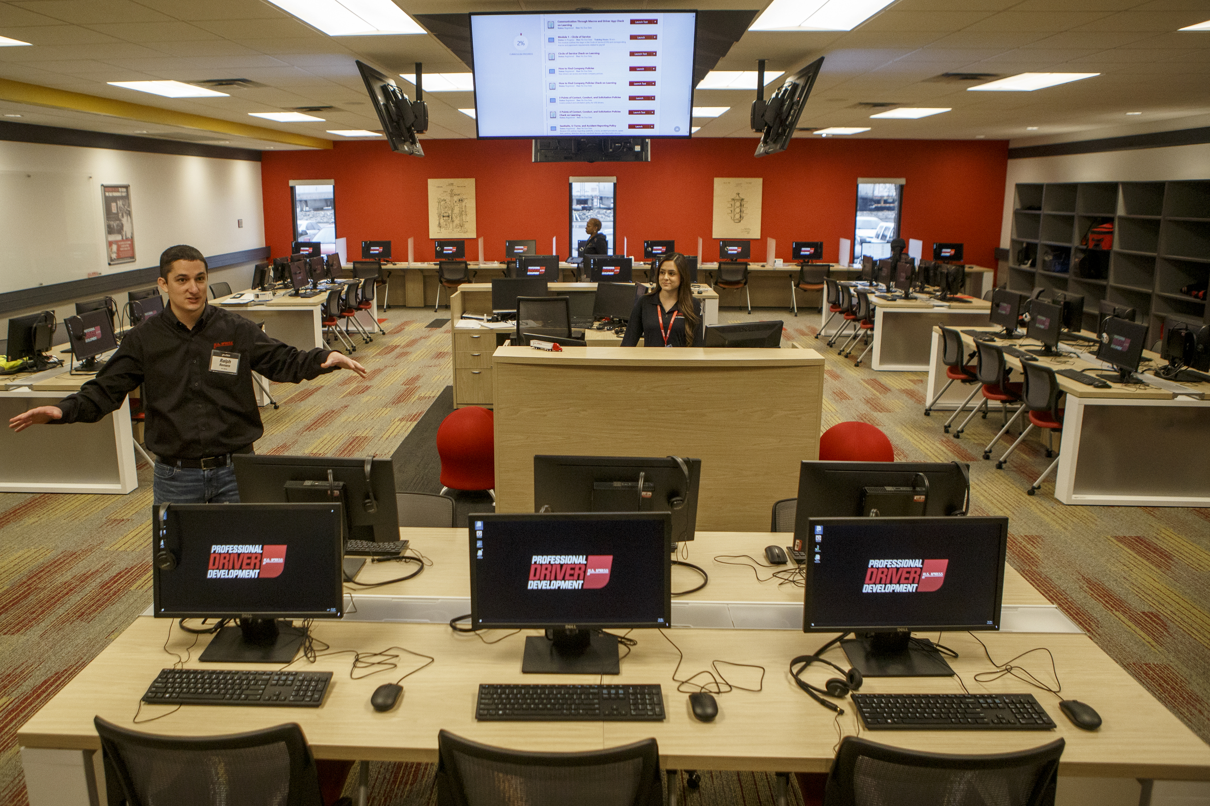 U.S. Xpress Vice President of Organizational Development Ralph Romero, left, talks about the computer lab, part of the Professional Driver Development program, at the U.S. Xpress Tunnel Hill facility on Tuesday, Feb. 19, 2019 in Tunnel Hill, Ga.