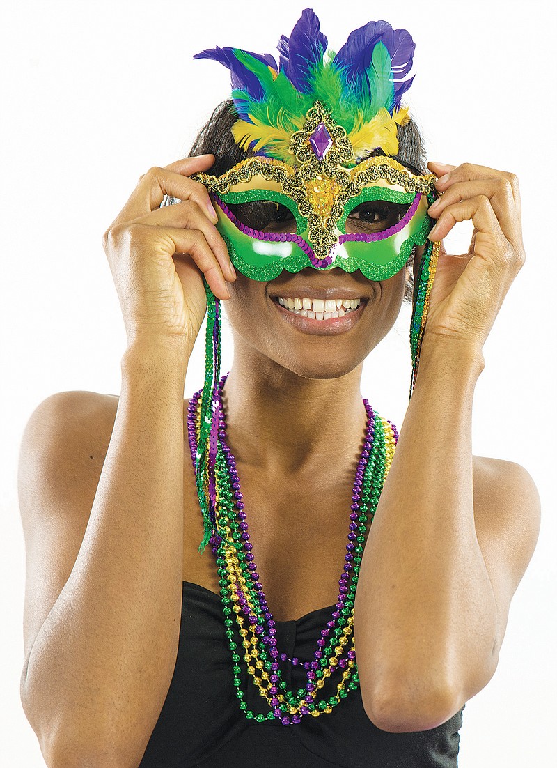 Woman wearing Mardi Gras mask with big smile