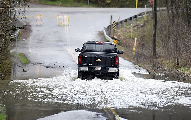 Staff Photo by Robin Rudd/
A pickup truck navigates the rising floodwaters of Mackey Branch on Davidson Road in East Brainerd on Broad Street on February 20, 2019. 