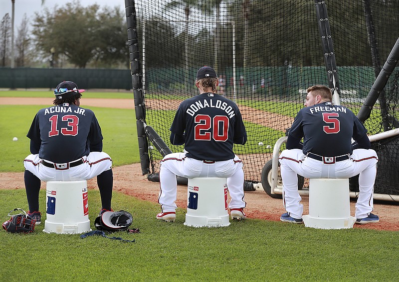 From left, Atlanta Braves players Ronald Acuna Jr., Josh Donaldson and Freddie Freeman wait their turns in the batting cage during the team's first full-squad workout of spring training on Thursday.