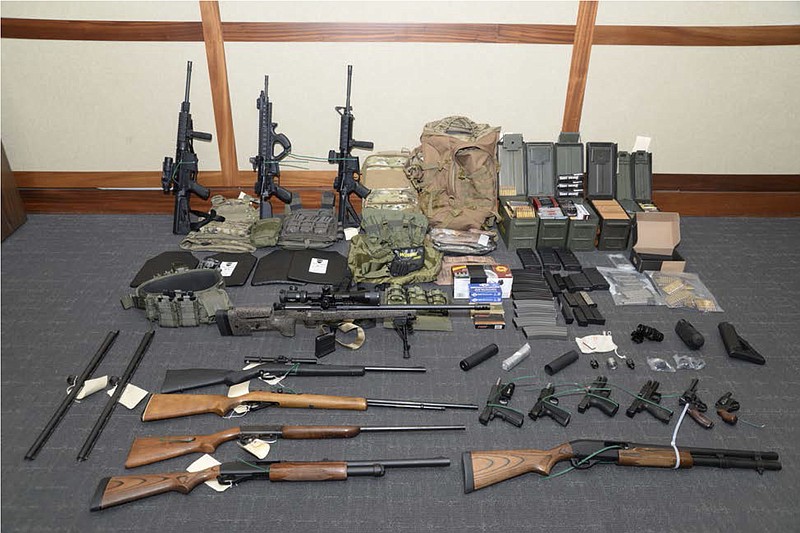 This image provided by the U.S. District Court in Maryland shows a photo of firearms and ammunition seized from Coast Guard Lt. Christopher Paul Hasson. Prosecutors say Hasson is a "domestic terrorist" who wrote about biological attacks and had a hit list that included prominent Democrats and media figures. (U.S. District Court via AP)