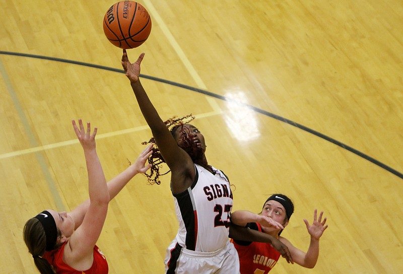 Signal Mountain's Lamiah Walker reaches for the basketball between Sequoyah's Abbey Borden, left, and Lauren Belcher during their Region 3-AA tournament game Friday night on Signal Mountain.