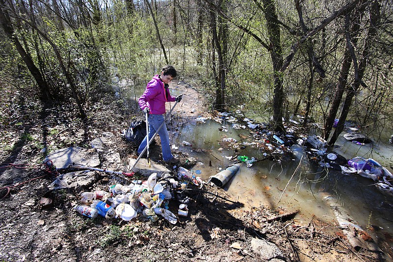 TenneSEA Executive Director Mary Beth Sutton removes trash from Chattanooga Creek during a volunteer cleanup event Sunday, February 24, 2019 in St. Elmo, Tennessee. The area is a known dumping ground where household trash, tires, old rugs, televisions and other contaminants can be seen along the roadway and in the creek.